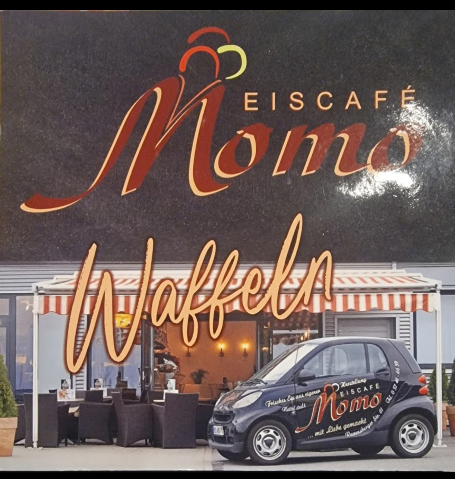 Eiscafé Momo – Schriftzug, Markenauto und beleuchtete Terrasse am Abend